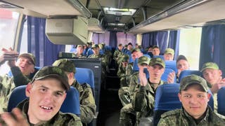 In this video grab taken from a handout footage released by the Russian Defence Ministry on 6 May, 2025, freed Russian prisoners of war (POWs) react sitting in a bus following a swap at an undisclosed location